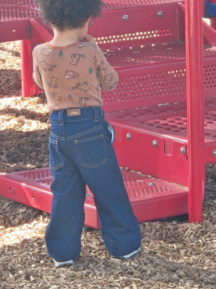 Child wearing Grow-Ease™ kids jeans while moving comfortably during everyday play