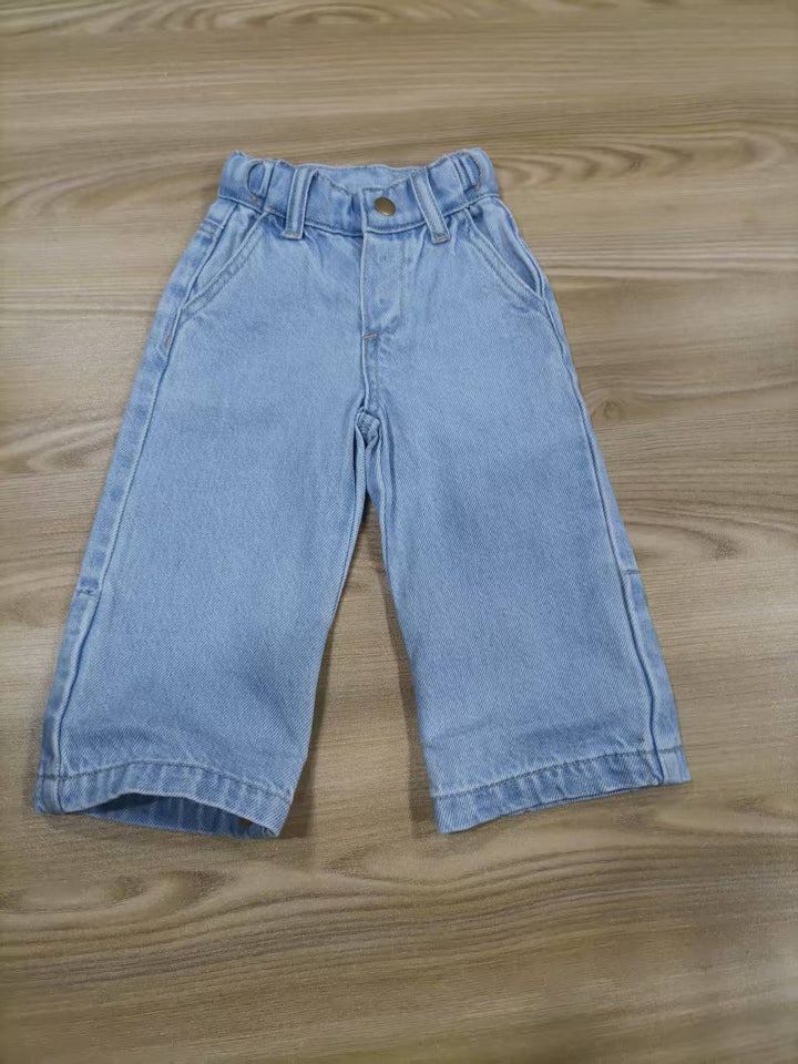 Grow-Ease™ kids jeans showing extendable hem feature that allows additional length as children grow. light blue jeans on wooden surface
