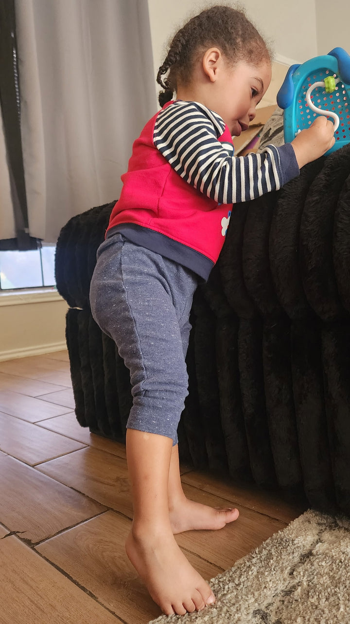 Child playing with a toy on a wooden floor